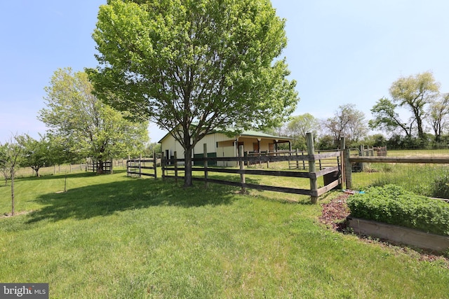 view of yard featuring an exterior structure, a rural view, and an outbuilding