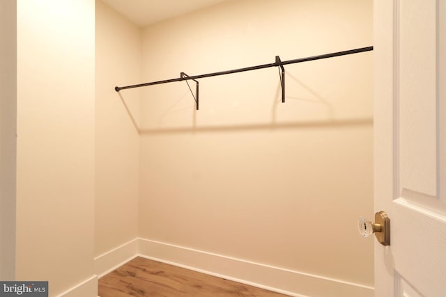 walk in closet with wood finished floors