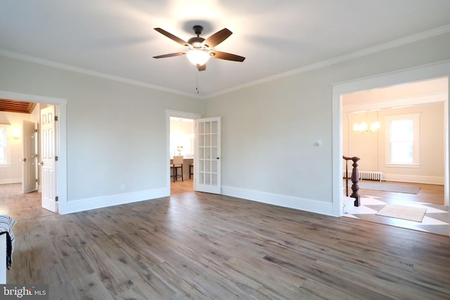 unfurnished room with ornamental molding, wood finished floors, french doors, baseboards, and ceiling fan