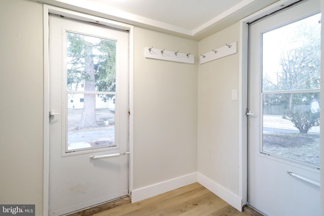 doorway to outside with baseboards and light wood finished floors