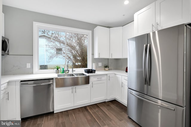 kitchen with a sink, stainless steel appliances, dark wood-style flooring, and decorative backsplash