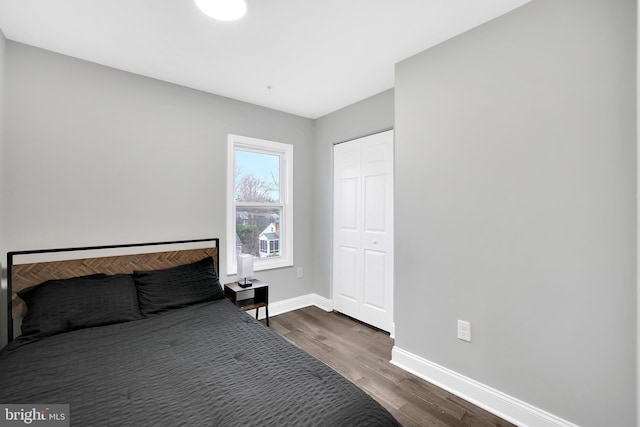 unfurnished bedroom featuring dark wood finished floors, baseboards, and a closet