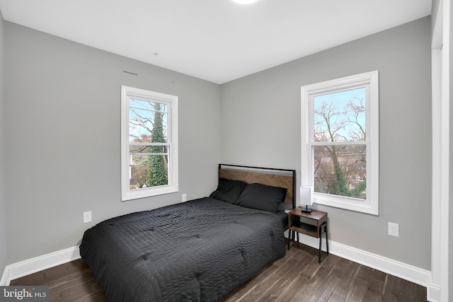 bedroom with baseboards and wood finished floors