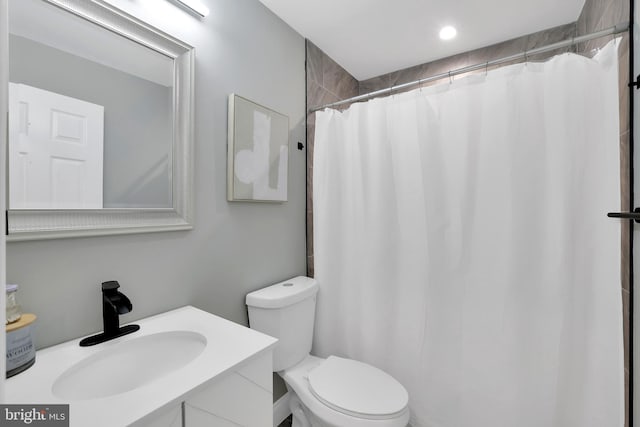 full bath featuring curtained shower, toilet, and vanity