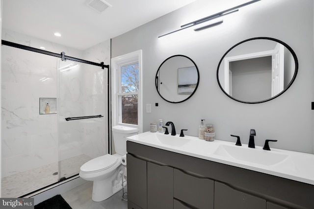 full bath featuring a sink, visible vents, toilet, and a marble finish shower