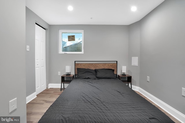 bedroom with recessed lighting, wood finished floors, and baseboards