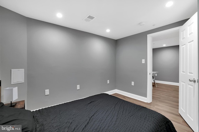 unfurnished bedroom featuring visible vents, recessed lighting, baseboards, and wood finished floors