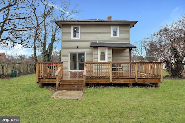 back of property featuring a deck, a chimney, a yard, and fence