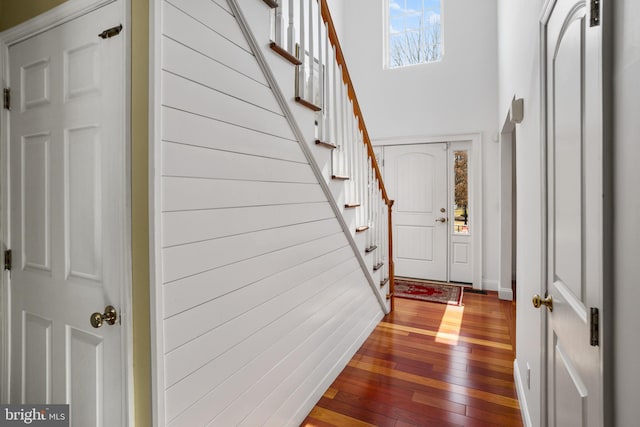 foyer featuring stairway, hardwood / wood-style floors, and a towering ceiling