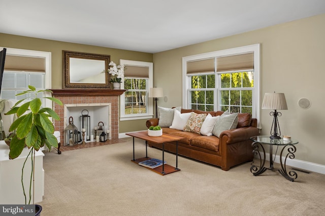 living area featuring visible vents, a fireplace, baseboards, and carpet