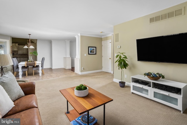 carpeted living area with visible vents, baseboards, ornamental molding, and decorative columns