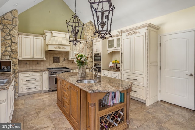 kitchen featuring a sink, stainless steel appliances, custom exhaust hood, and cream cabinets