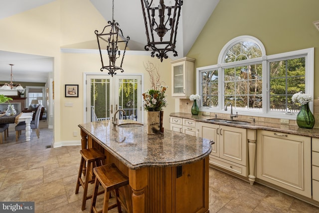 kitchen with a notable chandelier, cream cabinetry, and a sink