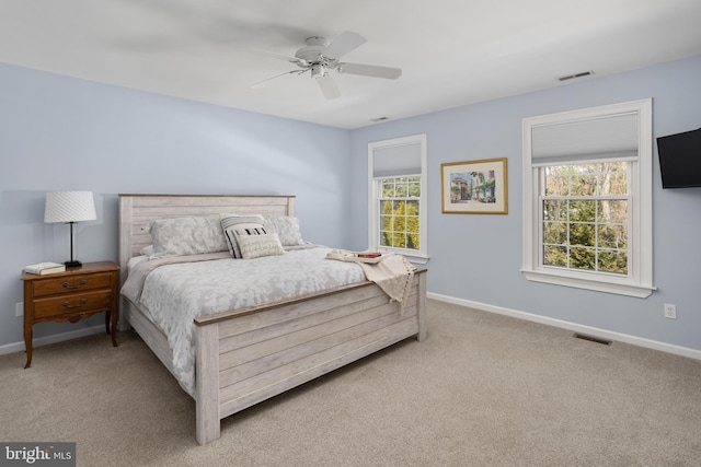 carpeted bedroom with multiple windows, baseboards, and visible vents