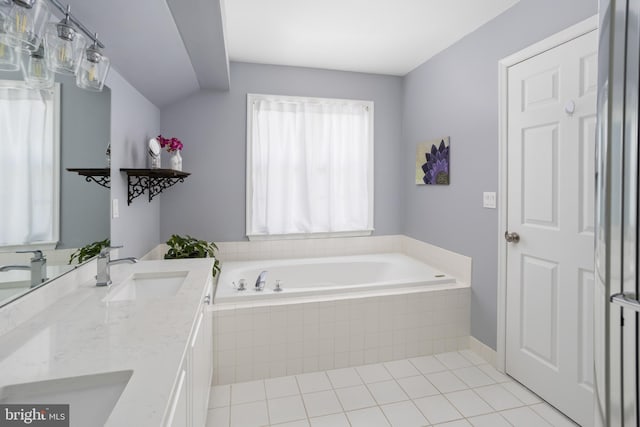 bathroom with tile patterned flooring, a garden tub, double vanity, and a sink