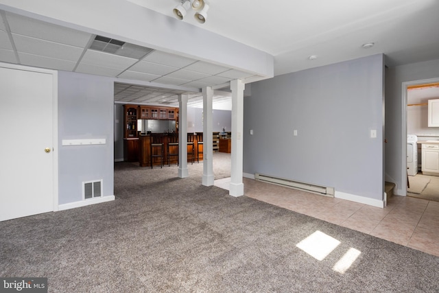 unfurnished living room with tile patterned flooring, carpet flooring, a baseboard heating unit, and visible vents