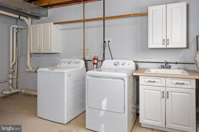 washroom featuring washer and clothes dryer, cabinet space, and a sink