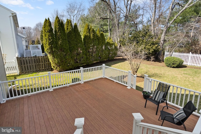 wooden terrace featuring a yard and fence