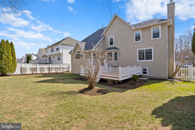 rear view of property featuring a wooden deck, a yard, a fenced backyard, and a chimney