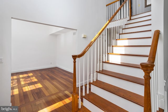 stairway featuring visible vents, wood finished floors, and baseboards