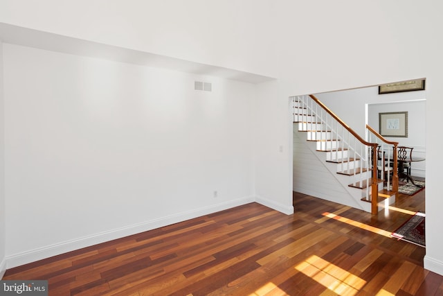 basement featuring stairway, wood-type flooring, baseboards, and visible vents