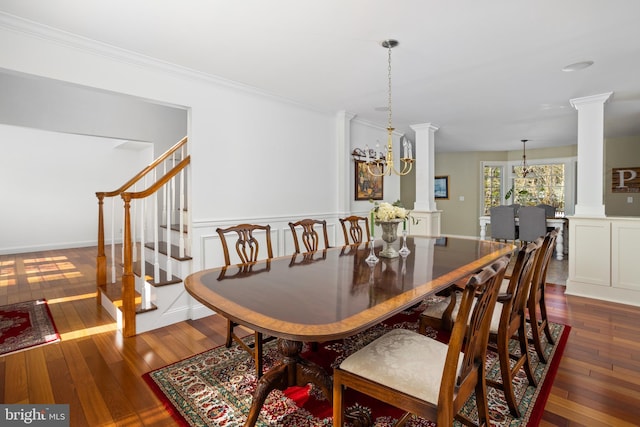 dining space featuring crown molding, stairway, dark wood-style flooring, and ornate columns