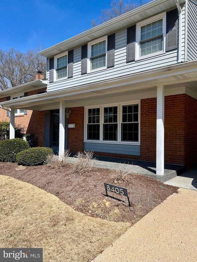 traditional-style home featuring brick siding and covered porch