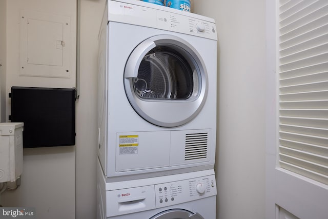 laundry room with electric panel, laundry area, and stacked washer and dryer