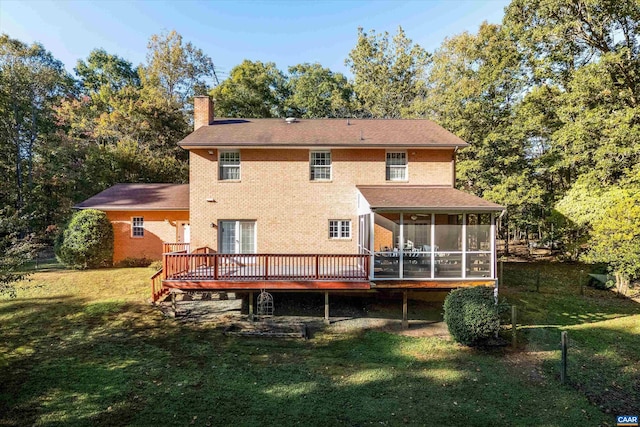 rear view of house with a wooden deck, a yard, a sunroom, a chimney, and brick siding