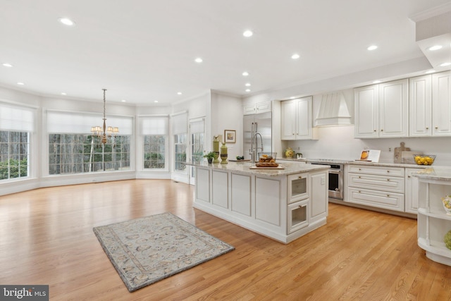 kitchen with built in appliances, plenty of natural light, ornamental molding, and custom range hood