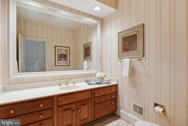 bathroom with wallpapered walls, vanity, visible vents, and tile patterned flooring