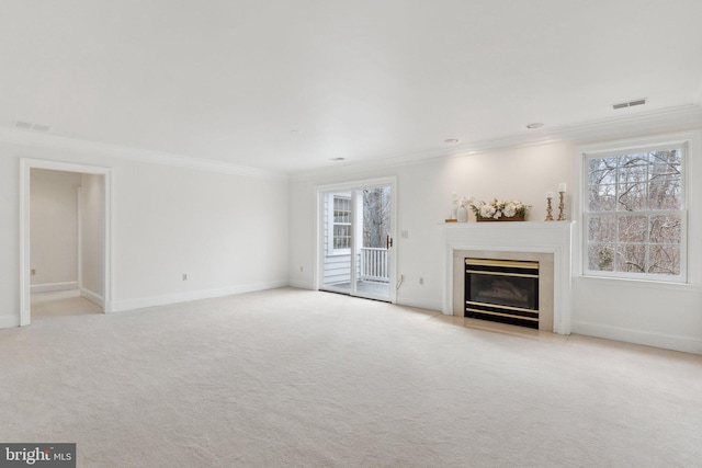 unfurnished living room with visible vents, a fireplace with flush hearth, carpet floors, and crown molding