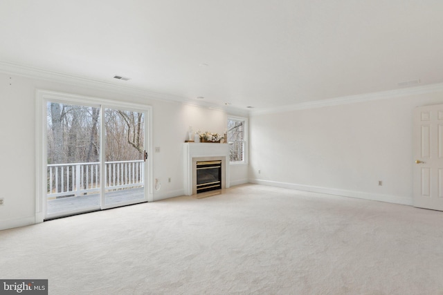 unfurnished living room featuring a fireplace with flush hearth, light colored carpet, baseboards, and ornamental molding