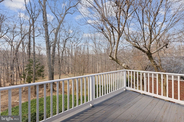 wooden terrace featuring a forest view