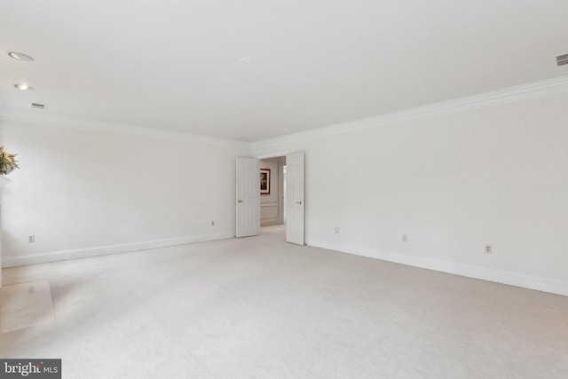 unfurnished room with baseboards, light carpet, and crown molding