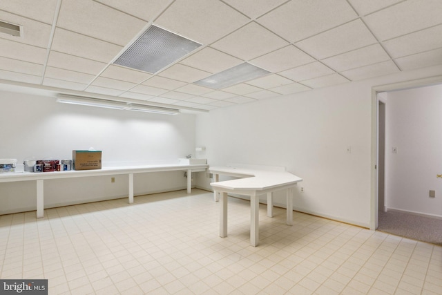 interior space featuring a drop ceiling, visible vents, and baseboards