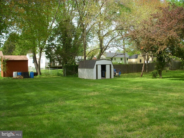 view of yard with central AC unit, an outdoor structure, a storage unit, and a fenced backyard