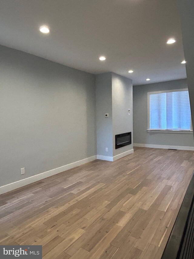 2869 Aramingo Ave, Philadelphia, PA 19134 - unfurnished living room featuring a glass covered fireplace, recessed lighting, and light wood-type flooring