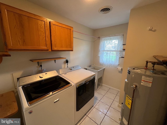 laundry area with visible vents, washing machine and clothes dryer, a sink, electric water heater, and cabinet space