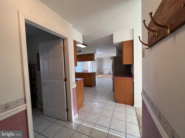 hall with light tile patterned flooring and a baseboard heating unit