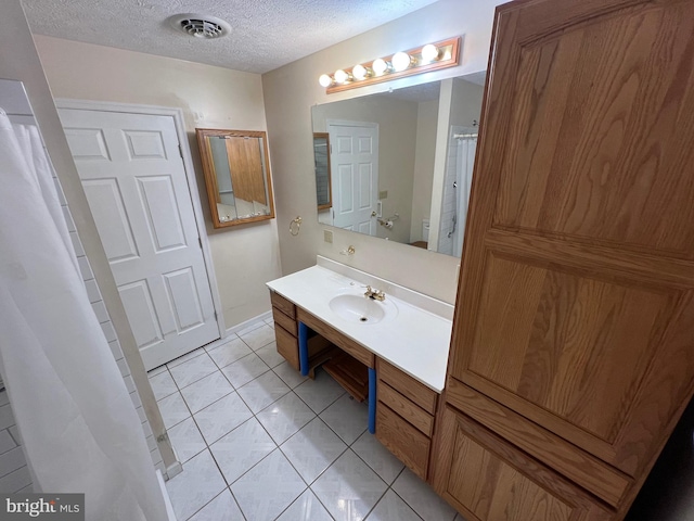 bathroom with vanity, tile patterned flooring, a textured ceiling, toilet, and visible vents