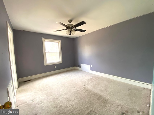 unfurnished room with visible vents, baseboards, light colored carpet, and ceiling fan