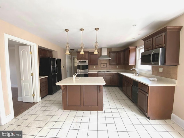 kitchen with a center island with sink, tasteful backsplash, appliances with stainless steel finishes, wall chimney exhaust hood, and light countertops