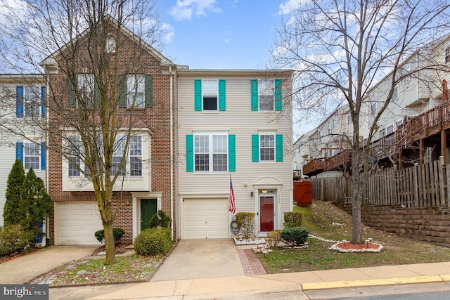 view of property featuring brick siding, an attached garage, concrete driveway, and fence