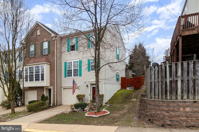 view of front of home featuring a garage, brick siding, driveway, and fence