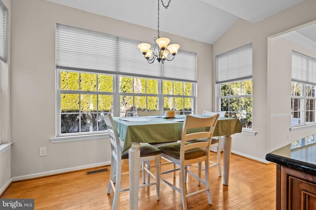 dining space with visible vents, baseboards, an inviting chandelier, and light wood finished floors