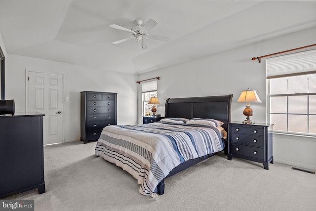 bedroom with a ceiling fan, baseboards, visible vents, and light carpet