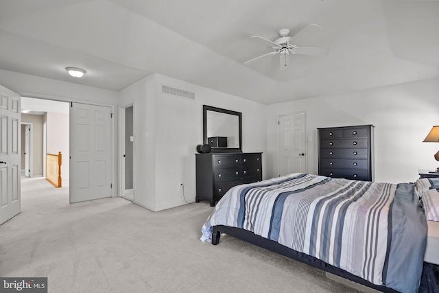 bedroom featuring visible vents, baseboards, ceiling fan, a tray ceiling, and carpet flooring