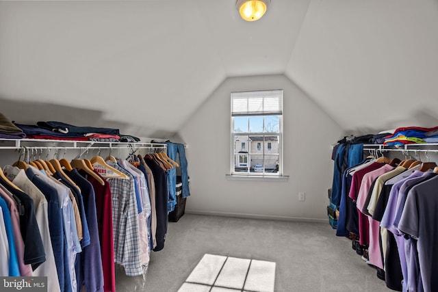 walk in closet with lofted ceiling and carpet