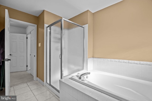 bathroom with tile patterned flooring, a shower stall, and a garden tub